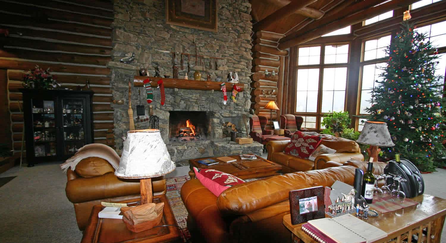 Living roomw ith large stone fireplace decorated for Christmas. 