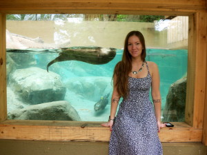 Woman standing in front of ottter aquarium