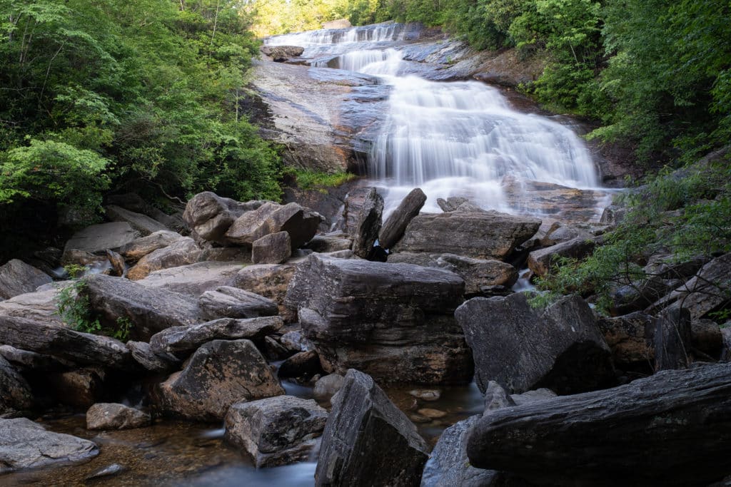 Gorgeous waterfall cascading own boulders flanked by lush vegetation