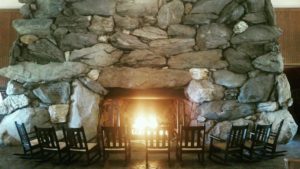 View of stone fireplace with fire