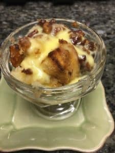 Glass Dessert cup on green plate filled with bread pudding and a creme anglaise custard