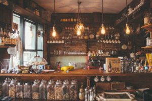 inside of a rustic bar, glasses, bottles, neatly organized. 