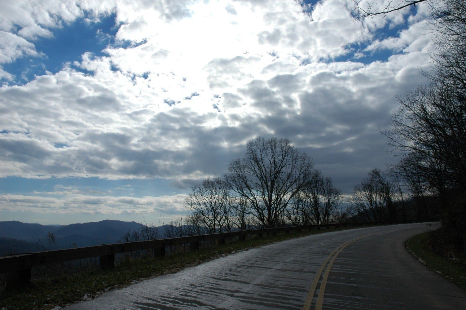 View from Blue Ridge Parkway of distant mountains amidst blue skies and white clouds