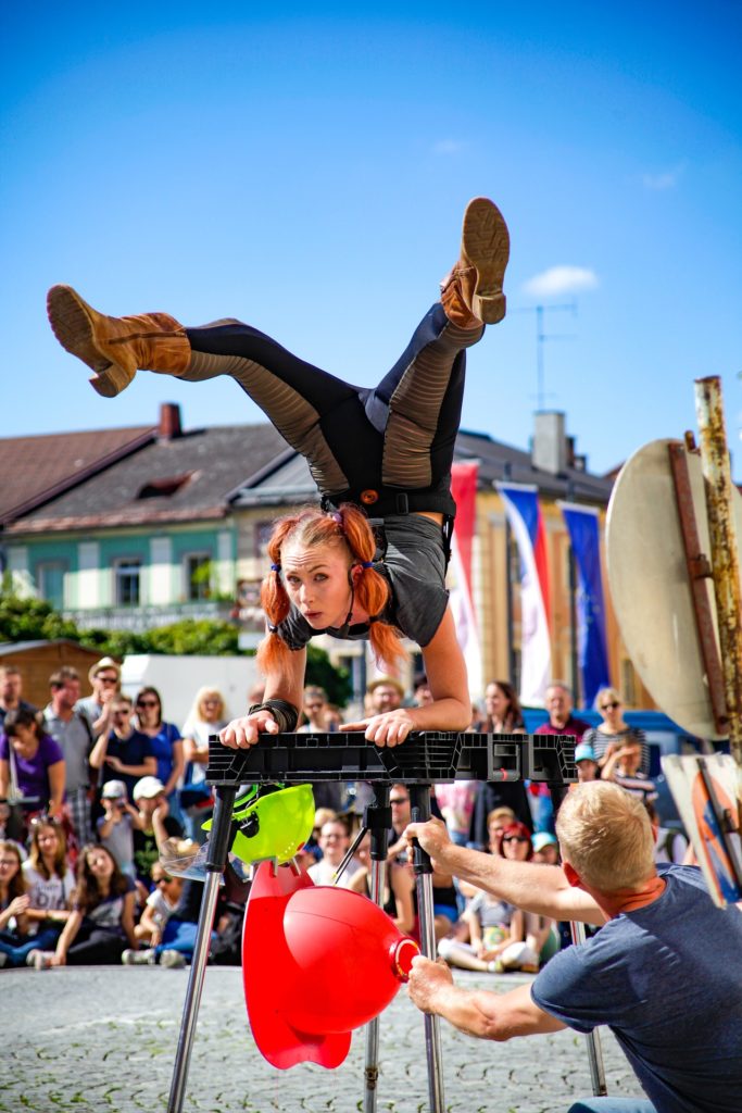 young woman with pigtails standing on arms in acrobatic move