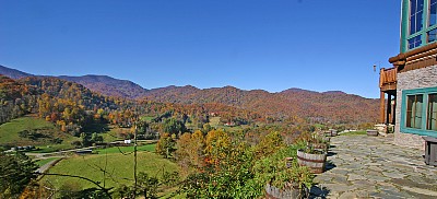 Panoramic view of the mountains and clear blue sky from the stone patio in front of the lodge.