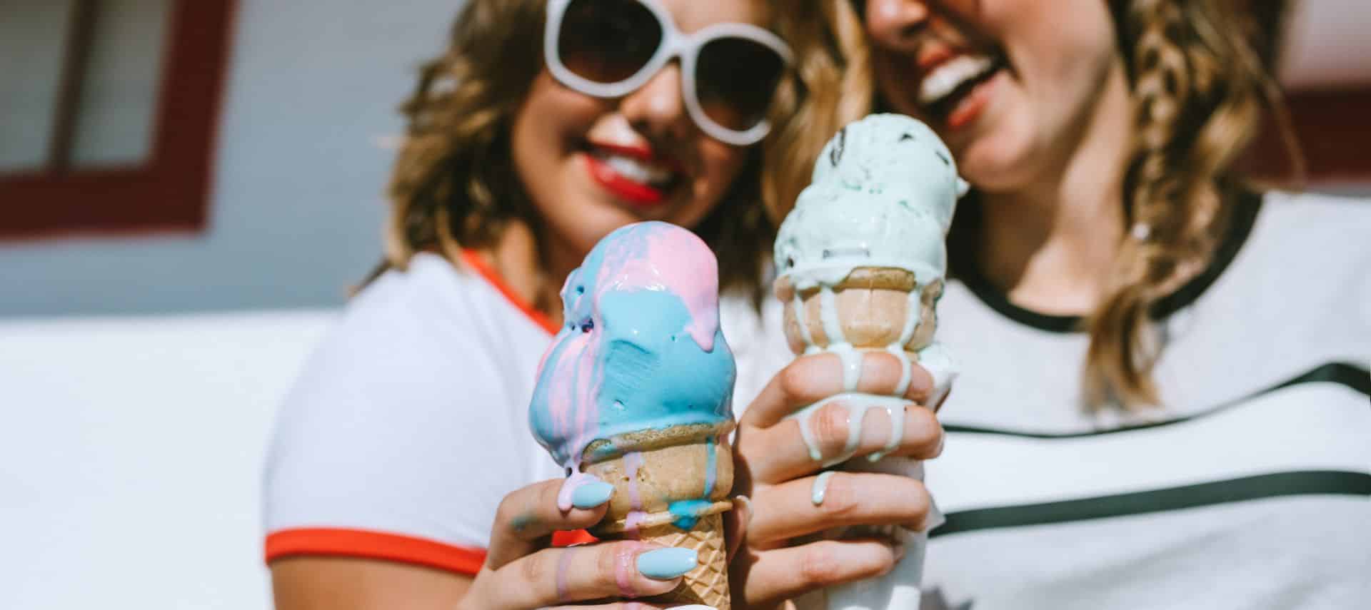 two women holding melting ice cream cones