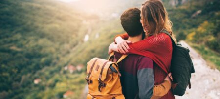 hiking couple hugging with mountain backdrop