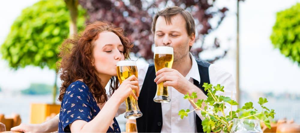 Man and woman sipping a beer on an outdoor patio 