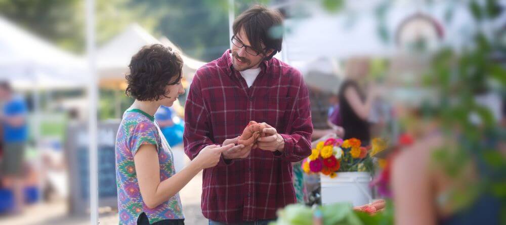 couple shopping at an outdoor farmers market